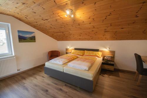 ein Schlafzimmer mit einem Bett und einer Holzdecke in der Unterkunft Ferienhaus Alois Navis in Navis