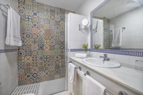 a bathroom with a sink and a shower at Zafiro Apartment&Parking in the historical centre in Córdoba