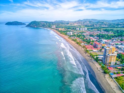 an aerial view of a beach with buildings and the ocean at SecretJaco - Luxury Beach Front Penthouse with Pool & Jacuzzi in Jacó