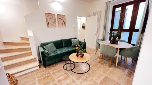 Affittacamere Casa Matilde في غالدو تادينو: غرفة معيشة مع أريكة خضراء وطاولة