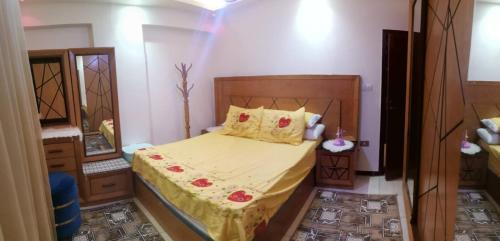 a small bedroom with a bed with a yellow blanket at الإسكندرية طوسون شارع المستشارين بجوار فتح الله ماركت in Abū Qīr