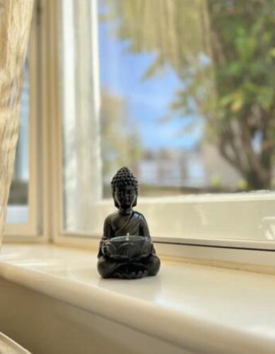 a small statue sitting on a window sill at Comfy double room in Clapham in London