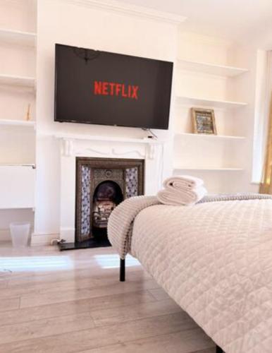 un soggiorno con TV e camino di Comfy double room in Clapham a Londra