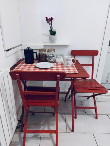 a red table with two chairs and a plate on it at Comfy double room in Clapham in London