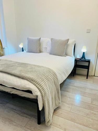 a bedroom with a large bed with a blanket on it at Comfy double room in Clapham in London