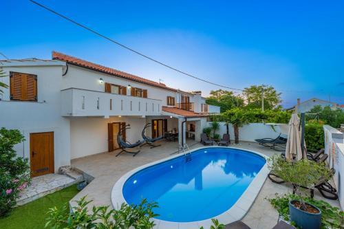 eine Villa mit einem Swimmingpool vor einem Haus in der Unterkunft Villa Goldie in Polje