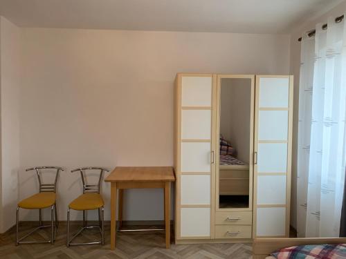 a room with a table and two chairs and a cabinet at Apartment Natali in Schnaittenbach