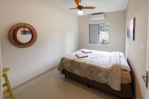 a bedroom with a bed and a mirror on the wall at Apto aconchegante com ar condicionado e wi-fi em rua tranquila in São Sebastião