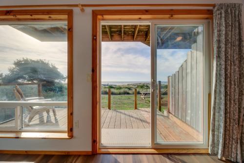 a room with a door open to a deck at Sanderling Sea Cottages, Unit 14 in Waldport