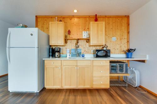 a kitchen with a white refrigerator and wooden cabinets at Sanderling Sea Cottages, Unit 14 in Waldport