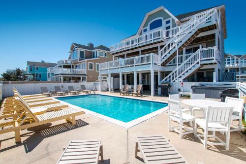 una piscina con sillas y una casa en BU70, Kings Landing- Oceanfront, Private Pool, Pool Table, Ocean Views, en Corolla