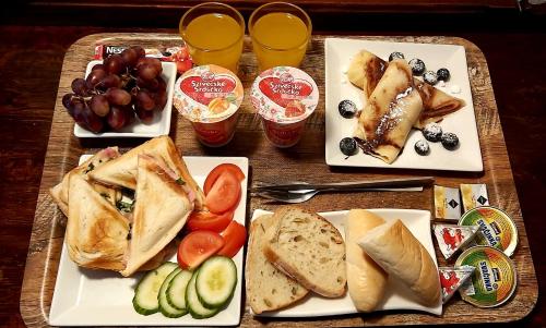 a table with plates of food and glasses of orange juice at Vivaldi Apartments in Mikulov