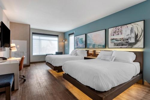 Cette chambre comprend deux lits et un bureau. dans l'établissement Cambria Hotel Minneapolis Downtown, à Minneapolis