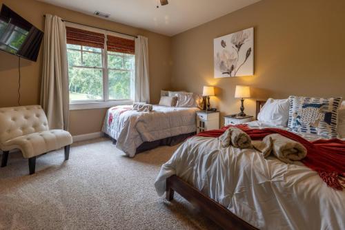 1 dormitorio con 2 camas, silla y ventana en Lakeview Retreat, en Oakwood