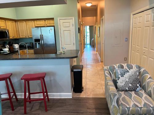 a kitchen with a couch and a counter with a refrigerator at Lovely 3-bedroom beach condo! Walk to shop or eat! in Pensacola