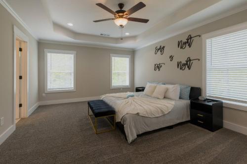 Un dormitorio con una cama y un ventilador de techo. en Just For Kicks, en Gainesville