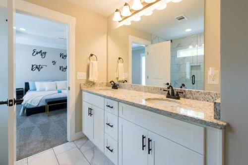 Un baño con lavabo y un espejo grande. en Just For Kicks, en Gainesville