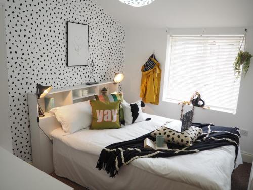 1 Schlafzimmer mit 2 Betten und einer Wand mit Polka-Punkten in der Unterkunft Spacious & Bright Flat, Cowley Rd in Oxford