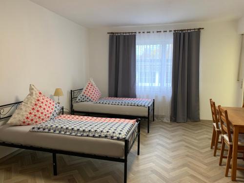 um quarto com duas camas e uma mesa e uma janela em Apartment Natali em Schnaittenbach