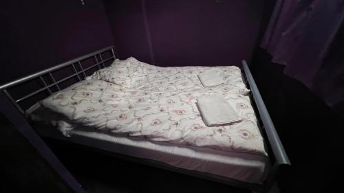 a bed with a white blanket and a book on it at St. Eric Appartman in Jászszentlászló
