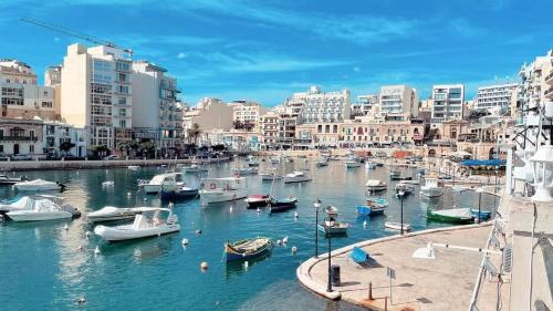 eine Gruppe von Booten in einem Hafen mit Gebäuden in der Unterkunft The Echo - R1 in Gżira