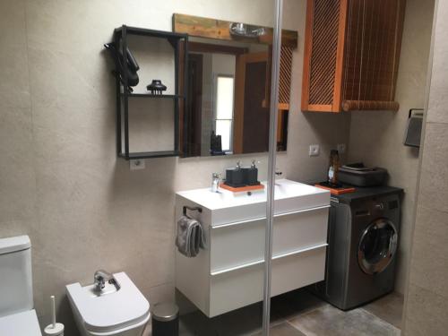 een badkamer met een wastafel en een wasmachine bij Bungalow LIDO-Playa Roca residence with sea front access - Free AC - Wifi in Costa Teguise