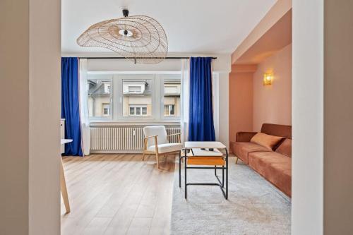 a living room with a couch and a table at Contemporain 1BR Rétro Chic Quartier Bonnevoie in Luxembourg