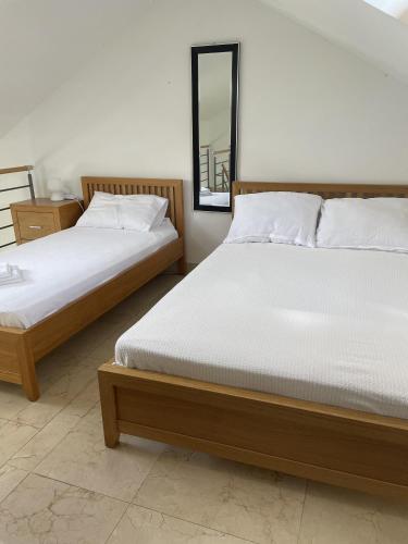 two beds sitting next to each other in a bedroom at 2 Bed Flat - Sleeps 6 - Pool - Garden - Parking in Milna