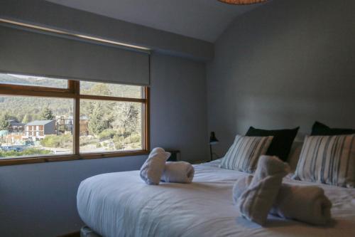 a bedroom with two beds with teddy bears on them at BOG Angostura Apartments in Villa La Angostura