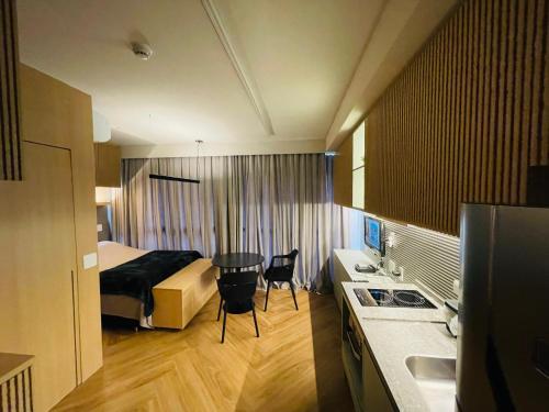 a hotel room with a bed and a kitchen with a table at Studio Nex One Itaim in Sao Paulo