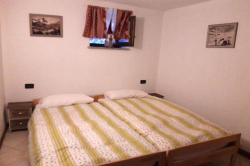 ein Schlafzimmer mit einem Bett mit einer gelben Decke in der Unterkunft Spectacular mountain hideaway in Antey-Saint-André