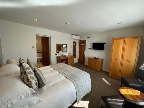 a bedroom with a large bed and a television at Le Friquet Hotel in Castel