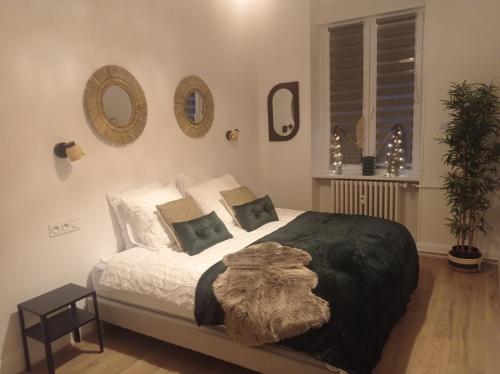 une chambre avec un grand lit avec une couverture dessus dans l'établissement Appart 3p RDC Orangerie- Parlement européen, à Strasbourg