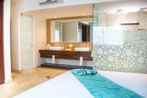 a bathroom with a bed and a large mirror at Hotel The Palm in Playa del Carmen