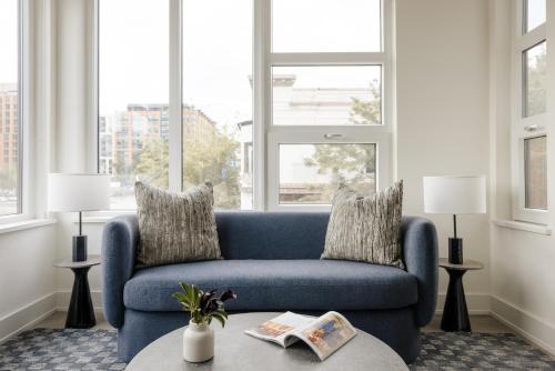 Sofá azul en la sala de estar con ventanas en Placemakr NoMa en Washington