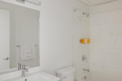 a white bathroom with a toilet and a shower at Reside NoMa, a Wyndham Residence in Washington