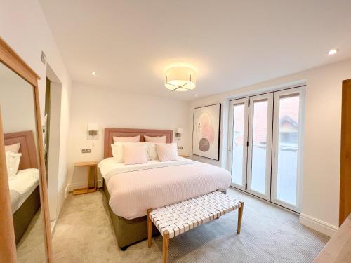 a bedroom with a bed and a bench in it at St Annes Beach Apartments in Lytham St Annes