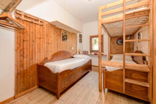 two bunk beds in a room with wooden walls at Chalet "Baita Cavacca" in Crone