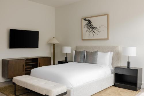 a bedroom with a white bed and a flat screen tv at Reside NoMa, a Wyndham Residence in Washington