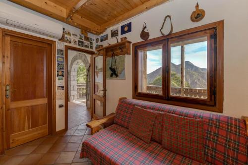 a living room with a couch and a window at Chalet "Baita Cavacca" in Crone