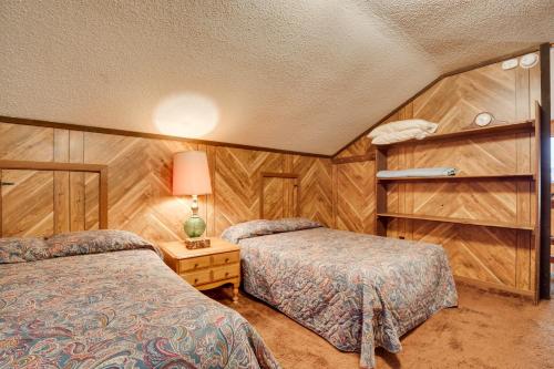 2 Betten in einem Zimmer mit Holzwänden in der Unterkunft Iron River Vacation Rental - Walk to Ski Brule! in Iron River