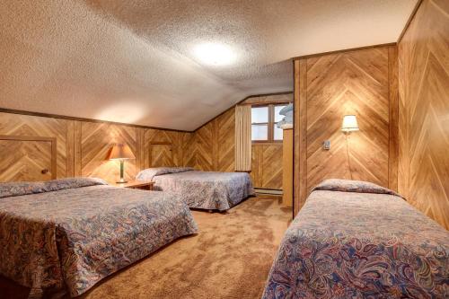 Iron RiverにあるIron River Vacation Rental with Ski Slope Views!のベッド2台が備わる木製の壁の客室です。