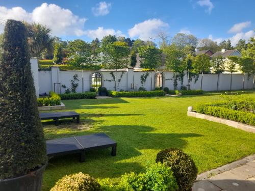 a garden with two benches in the grass at Nordav Guesthouse in Clonakilty