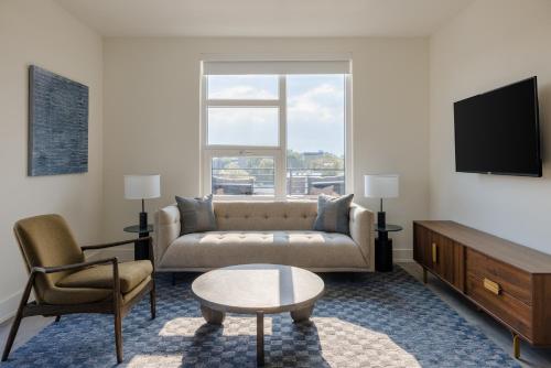 a living room with a couch and a tv at Reside NoMa, a Wyndham Residence in Washington
