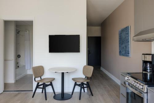 a kitchen with a table and chairs and a tv at Reside NoMa, a Wyndham Residence in Washington