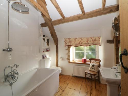 a bathroom with a tub and a toilet and a sink at The Miller's Cottage in Okehampton