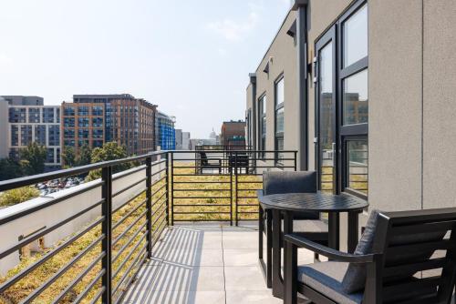 a balcony with a table and chairs on a building at Placemakr NoMa in Washington, D.C.