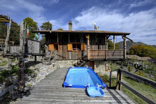 a house with a swimming pool in front of a building at Chalet "Baita Cavacca" in Crone