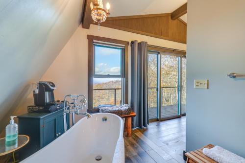 ein Bad mit einer Badewanne und einem großen Fenster in der Unterkunft Wolf Laurel Resort Home with Long Range Views! in Swiss
