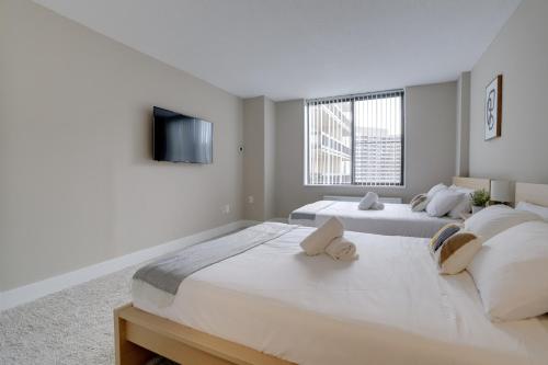 dwa łóżka w sypialni z telewizorem na ścianie w obiekcie Elegant Condo for Business Travelers @Crystal City w mieście Arlington